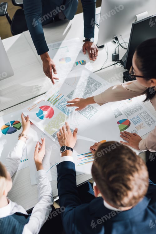 Preview: cropped shot of young business team working with charts and graphs in office