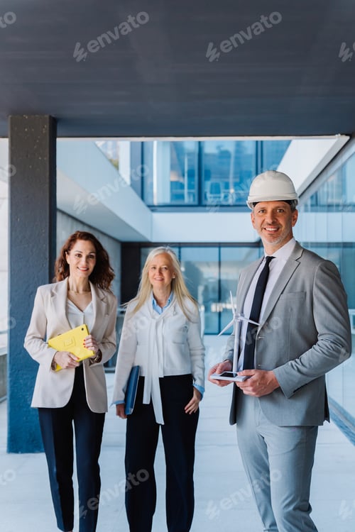 Preview: An engineer holds a model of a wind turbine next to his female business partners