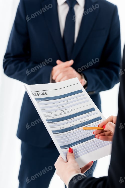 Preview: cropped view of woman holding resume and pencil near man with clenched hands