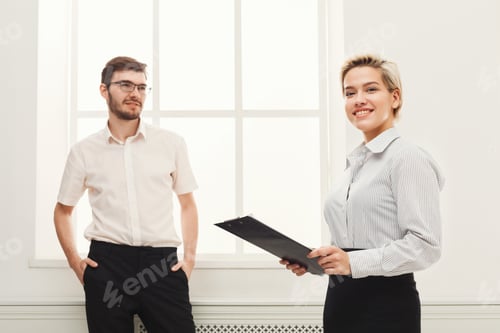 Preview: Happy Couple Of Young Colleagues Working In Modern Office. Focused Buninesswoman Holding Documents