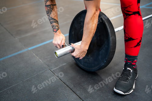 Preview: Woman securing a clamp at a weightlifting bar