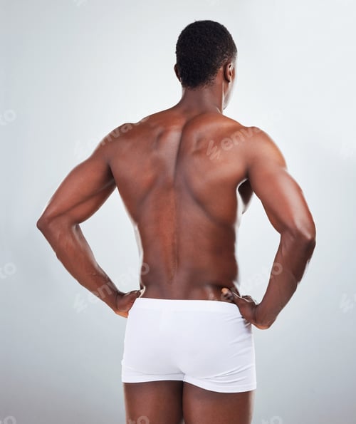 Preview: Rear view of one African American fitness model posing topless in a underwear and looking muscular.