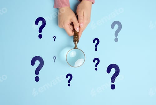 Preview: Female hand holds a wooden magnifying glass and question marks on a blue background.