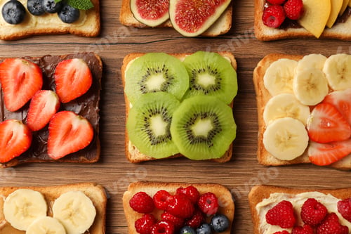 Preview: Tasty toasts with different spreads and fruits on wooden table, flat lay