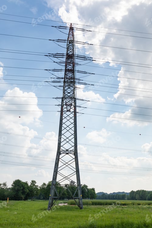 Preview: Vertical shot of a transmission tower on a cloudy blue sky