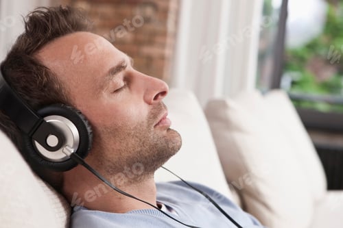 Preview: Germany, Man sitting on couch and listening music