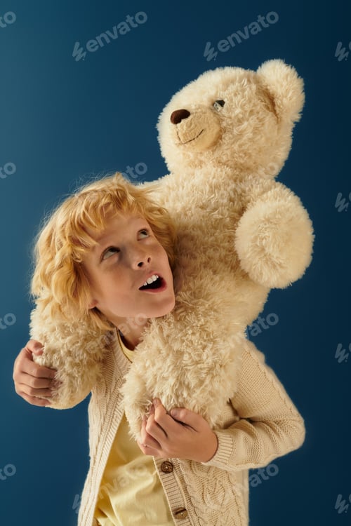 Preview: Blonde boy embracing a large plush bear against a calming blue backdrop