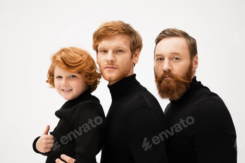 Preview: bearded men in black sweaters looking at camera near happy kid showing thumb up isolated on grey
