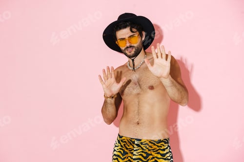 Preview: Young shirtless man wearing shorts showing stop gesture on camera