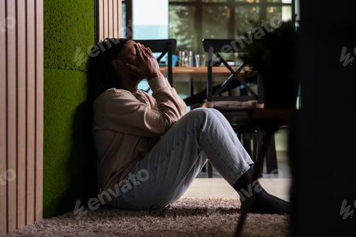 Preview: Young adult, African American, overwhelmed and unfulfilled, sitting on the floor