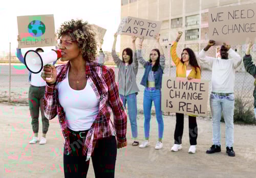Preview: African American woman shouts with megaphone leading demonstration against climate change.