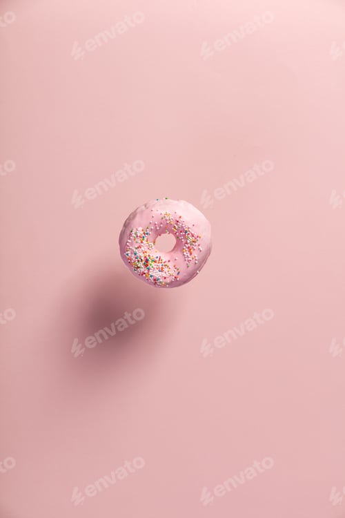 Preview: Pink doughnut with sprinkles falling or flying in motion