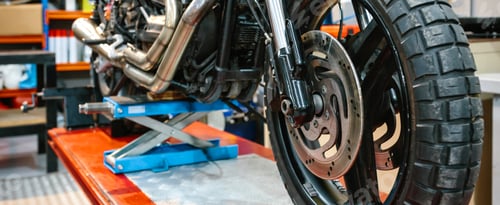 Preview: Banner of front wheel tyre and brake disk of custom motorbike on workshop