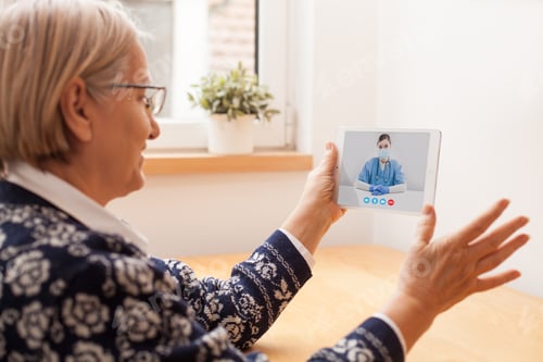 Preview: Elderly caucasian woman talking to young female UK e-doctor via online video chat