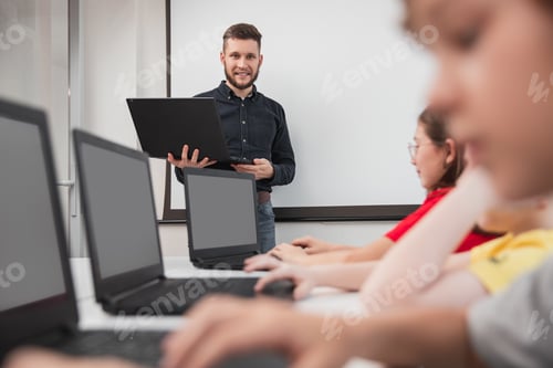 Preview: Company of children using laptops during lesson