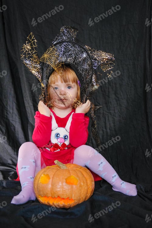 Preview: Girl With A Pumpkin Instead Of A Head On A Dark Background. Pumpkin Lantern And Angled Witch Hat In