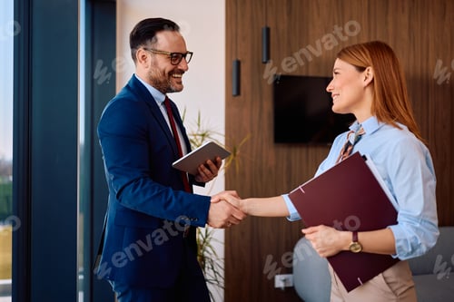 Preview: Happy CEO greeting female job candidate in the office.