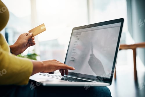 Preview: Cropped shot of a woman using her credit card to make an online payment at home