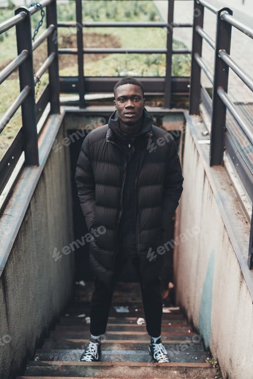 Preview: portrait of young african man standing in the street and looking camera