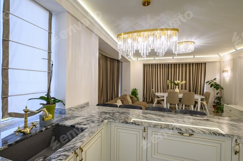 Preview: Cream-colored classic kitchen with island used as dining area in studio flat