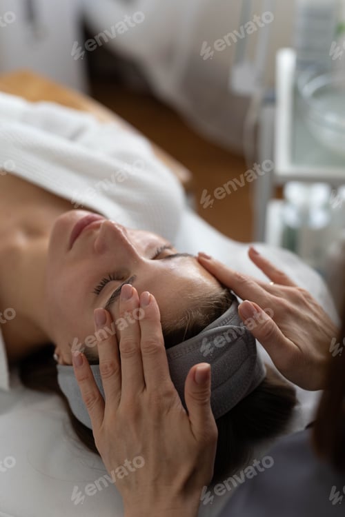 Preview: A beautiful woman enjoys a facial massage at a spa salon,indulging in skin and body care treatments.