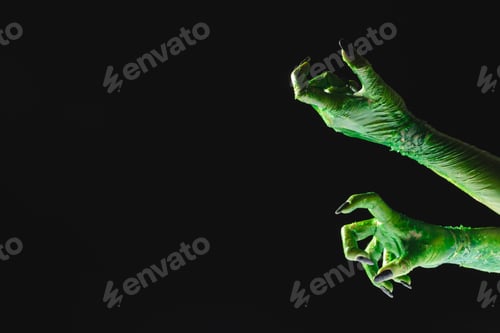 Preview: Green monster hands with black nails reaching on black background