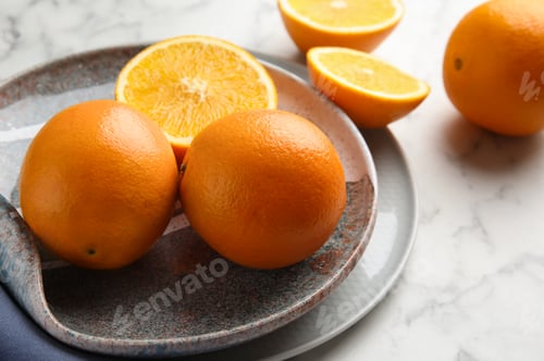 Preview: Plate with fresh juicy oranges on marble table