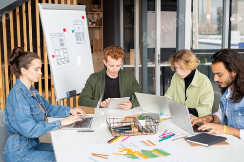 Preview: Young contemporary co-workers in casualwear using mobile gadgets in office