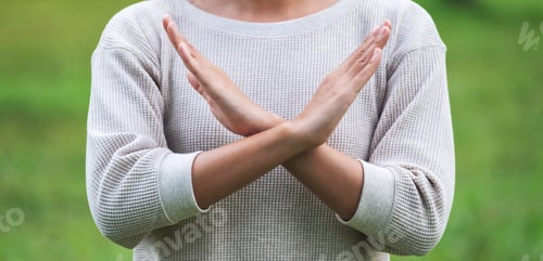 Preview: Closeup image of a woman making crossed arms sign