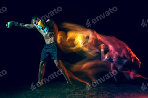 Preview: Male boxer boxing in a dark studio