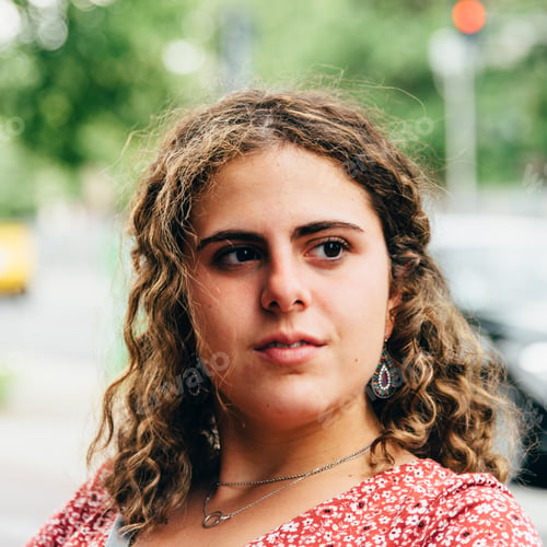 Preview: Headshot portrait of confident beautiful young woman with curly hair.