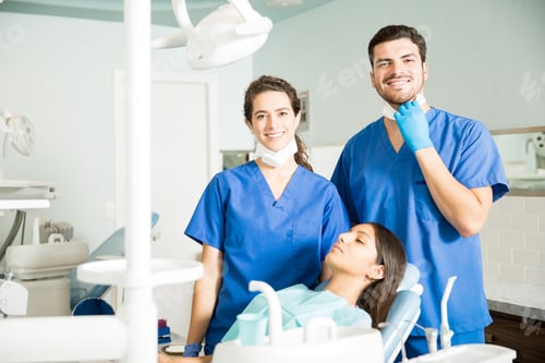 Preview: Portrait Of Smiling Dentists Standing By Patient At Clinic