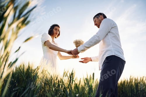 Preview: Against beautiful sunlight. Couple just married. Together on the majestic agricultural field