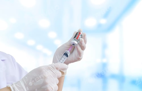 Preview: doctor hand holding syringe with covid-19 vaccine vial prepare for injection in hospital room