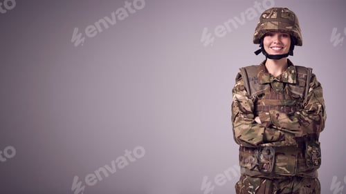 Preview: Studio Portrait Of Smiling Young Female Soldier In Military Uniform Against Plain Background