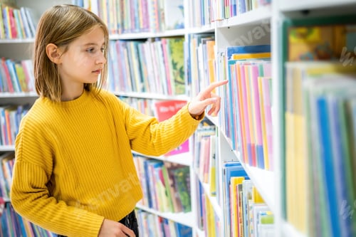 Preview: Schoolgirl choosing book in school library.