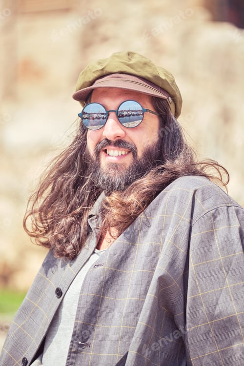 Preview: Happy man in cap on street