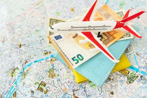Preview: Paris city map composition with euro banknotes, dollars, passports and a toy plane. Travel and