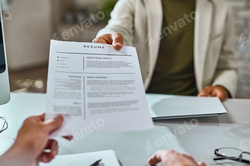 Preview: Close-up of candidate giving his CV on a job interview.