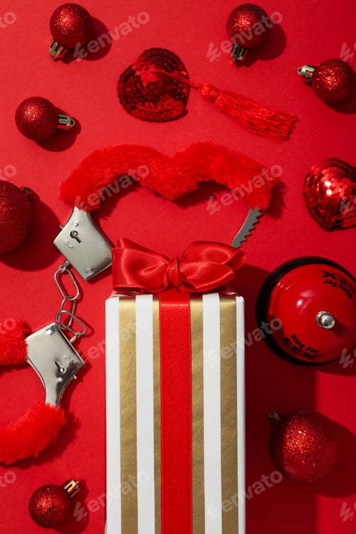Preview: Sex toy with New Year's decor on a red background.