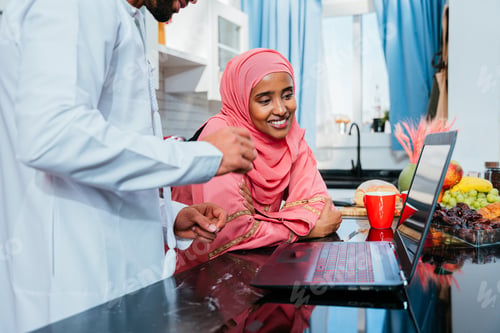 Preview: Happy middle eastern couple wearing traditional arab clothing at home