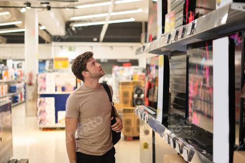 Preview: Male shopper examining TV on shelf