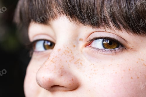 Visualização: Vista aproximada do rosto sardento da criança com olhos expressivos