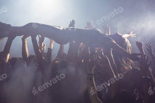 Preview: Cheerful crowd lifting female performer at nightclub