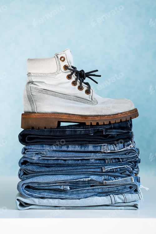 Preview: Stylish White Boot on Stack of Denim Jeans