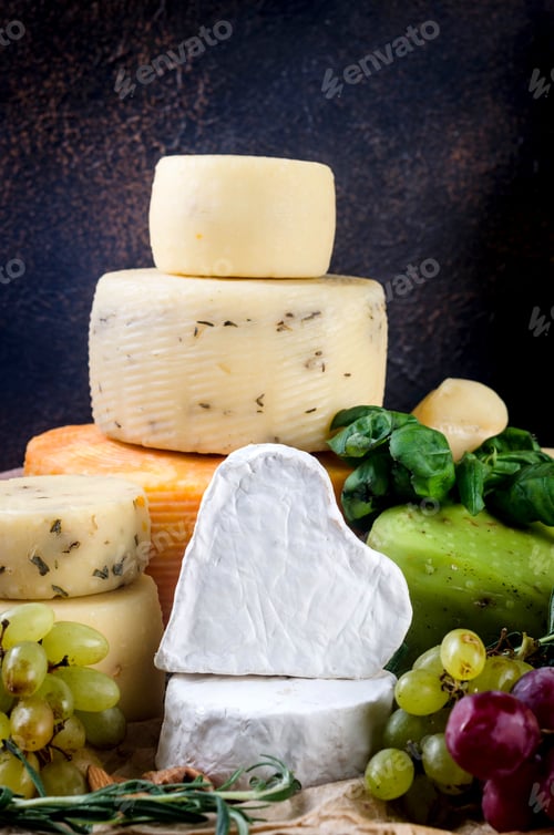 Preview: cheese heads of different kinds stacked on table