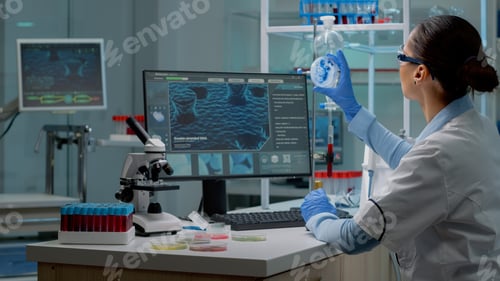 Preview: Innovation scientist studying petri dish with liquid bacteria