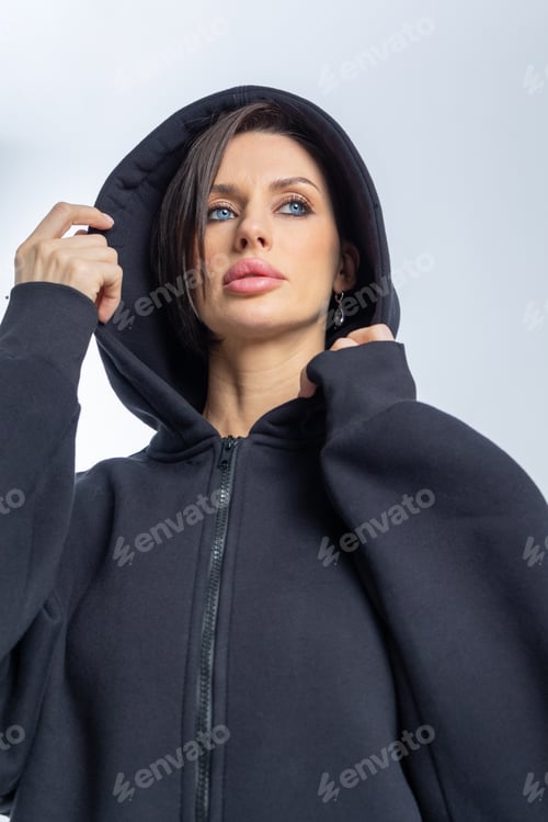 Preview: Portrait beautiful woman of model appearance. Girl in black sweatshirt on grey background. Pretty