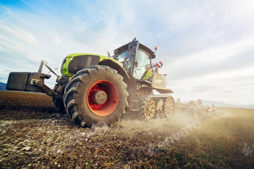 Preview: Modern tractor working on the field. Tractor plowing fields preparing land for sowing