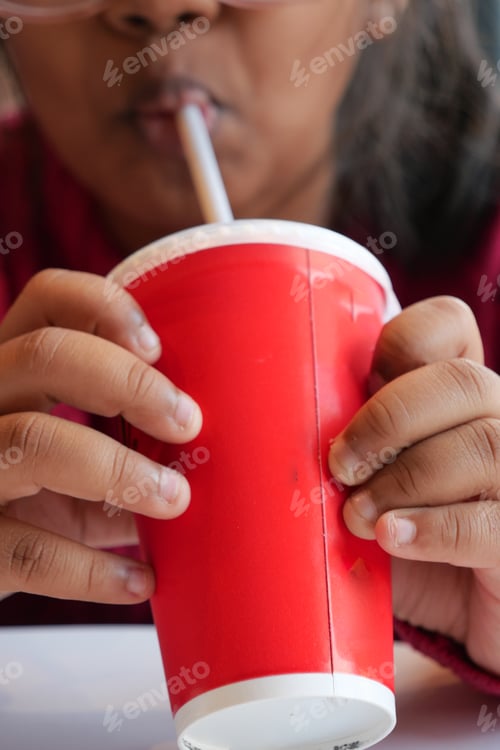 Preview: A Person Happily Enjoying a Refreshing Beverage from a Bright Red Cup